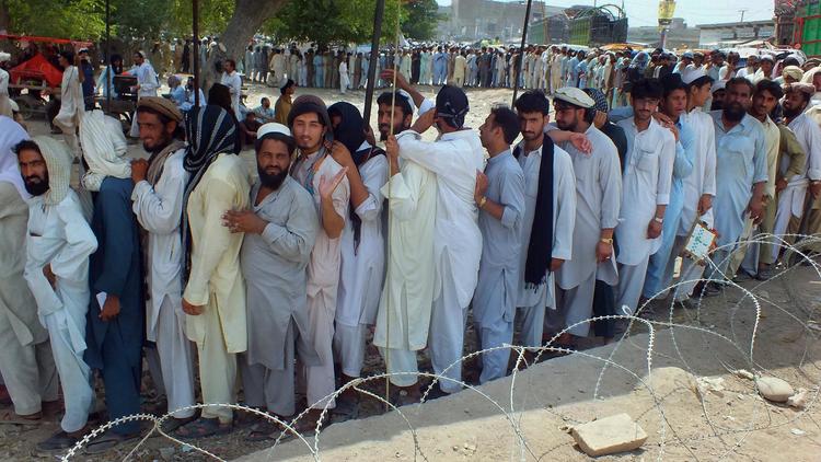 Des déplacés pakistanais suite à l'offensive militaire contre les talibans dans le Waziristan du Nord font la queue pour une distribution de nourriture à Bannu, le 26 juin 2014 [Karim Ullah / AFP]