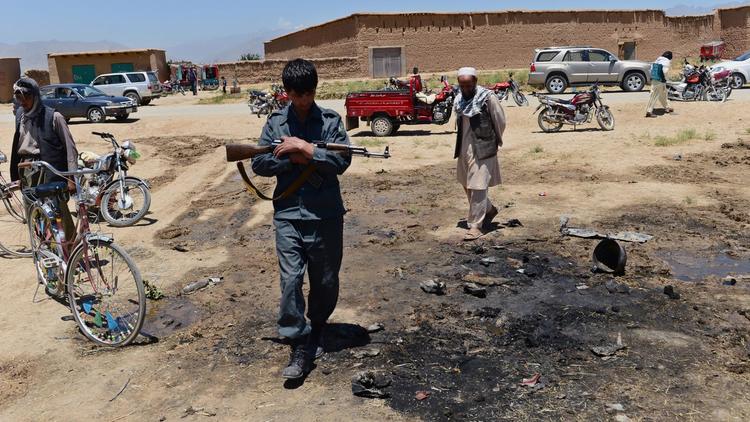 Un policier afghan sur le site d'un attentat-suicide qui a fait 16 morts dont 10 civils, le 8 juillet 2014 dans la région de Parwan [Wakil Kohsar / AFP]