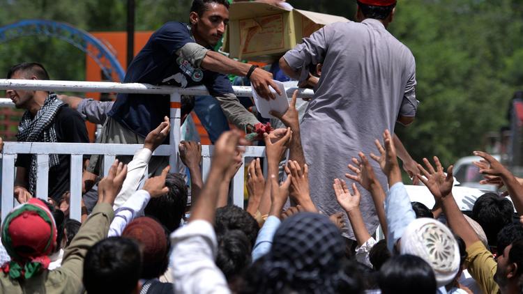 Des partisans du prêcheur Tahir-ul-Qadri et de Imran Khan reçoivent de la nourriture lors d'une manifestation à Islamabad le 17 août 2014 [Aamir Qureshi / AFP]