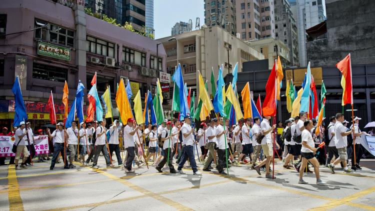 Des manifestants défilent à Hong Kong pour soutenir le gouvernement local contre un mouvement de désobéissance civile qui menace de paralyser la mégapole financière, le 17 août 2014 [Alex Ogle / AFP]