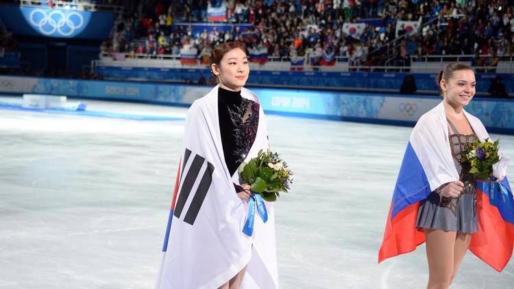 La Sud-Coréenne Kim Yu-na (G) pose avec la Russe Adelina Sotnikova (D) lors de la cérémonie de remise de bouquets au palais des glaces Iceberg à Sotchi, le 20 février 2014  [ / AFP/Archives]