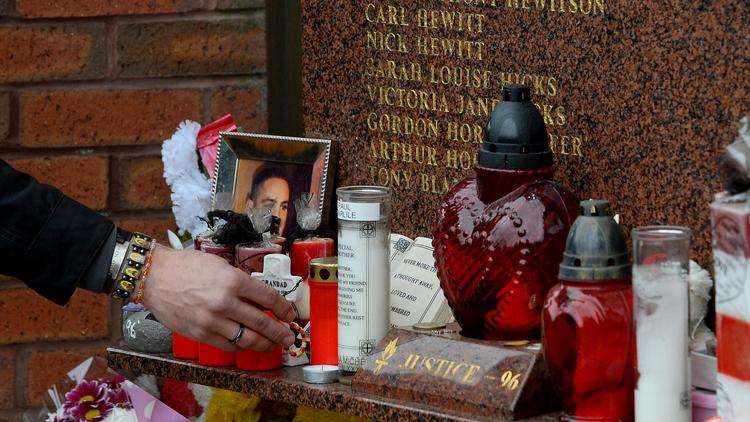 Bougies, photos et fleurs ornent la plaque en hommage à la catastrophe d'Hillsborough le 13 avril 2014 à Liverpool [Andrew Yates / AFP]
