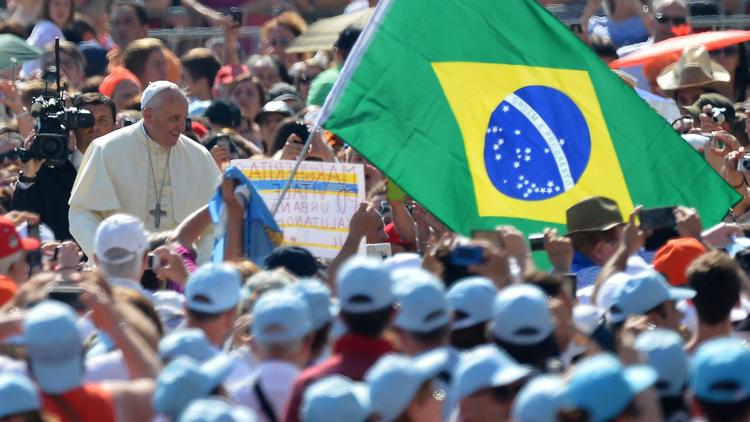 Le pape François sur la place Saint-Pierre, à proximité d'un drapeau du Brésil où a lieu le Mondial de football, le 11 juin 2014 à Rome. [Vincenzo Pinto / AFP]