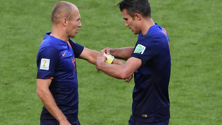 Les attaquants néerlandais Arjen Robben (g) et Robin van Persie (d) s'échangent le brassard de capitaine lors du match Pays-Bas - Australie, le 18 juin 2014 au stade Beira-Rio à Porto Alegre [ / AFP/Archives]