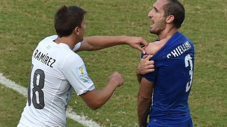 Le défenseur italien Giorgio Chiellini (d) montre son épaule mordue par l'attaquant uruguayen Luis Suarez, le 24 juin 2014 à Natal  [Yasuyoshi Chiba  / AFP]