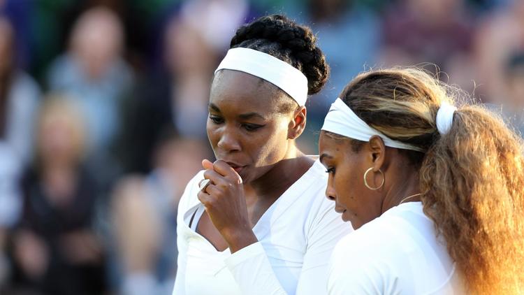 L'Américaine et N.1 mondiale Serena Williams (droite) et sa soeur Venus Williams (gauche) durant le double dames les opposant aux Ukrainiennes à Wimbledon le 25 juin 2014 [Andrew Cowie / AFP]