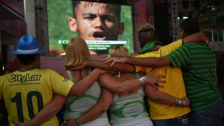 Des supporteurs brésiliens unis pendant leur hymne avant le match Brésil-Chili, dans l'école de samba Mangueira à Rio, le 28 juin 2014 [Yasuyoshi Chiba / AFP]