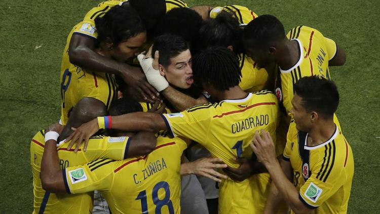 James Rodriguez (c) félicité par ses coéquipiers colombiens après le premier de ses deux buts contre l'Uruguay, le 28 juin 2014 à Rio [Felipe Dana / POOL/AFP]