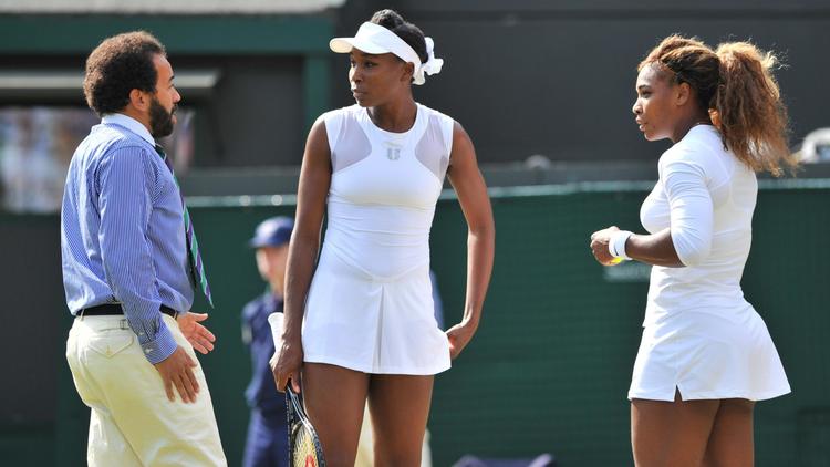 Les soeurs Venus et Serena Williams lors d'une rencontre de double à Wimbledon contre l'Allemande Kristina Barrois et la Suissesse Stefanie Voegele, le 1er juillet 2014. [Glyn Kirk / AFP/Archives]