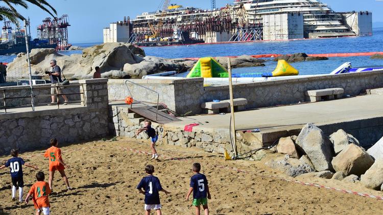 Des enfants jouent au football sur une plage de l'île de Giglio, le 19 juillet 2014 [Giuseppe Cacace / AFP]