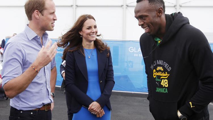 La star jamaïcaine Usain Bolt (d) plaisante avec le couple princier du Royaume-Uni, Kate (c) et William, pendant leur visite du village des Jeux du Commonwealth, le 29 juillet 2014 [ / POOL/AFP]