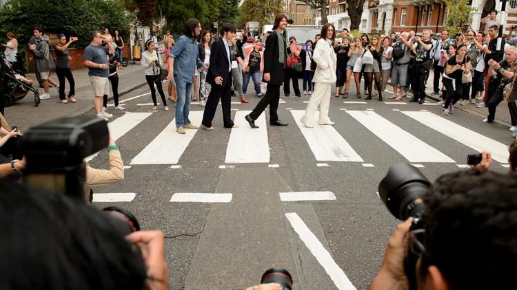 La troupe de la comédie musicale "Let it be" pose sur le fameux passage d'Abbey road, popularisé par les Beatles, le 8 aout 2014 à Londres pour marquer le 45e anniversaire de la photographie [Leon Neal / AFP]
