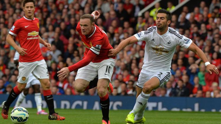 L'attaquant anglais de Manchester United Wayne Rooney à la lutte avec le défenseur de Swansea Jordi Amat lors d'un match comptant pour la 1re journée de championnat d'Angleterre, le 16 août 2014 à Old Trafford, Manchester. [Paul Ellis / AFP]