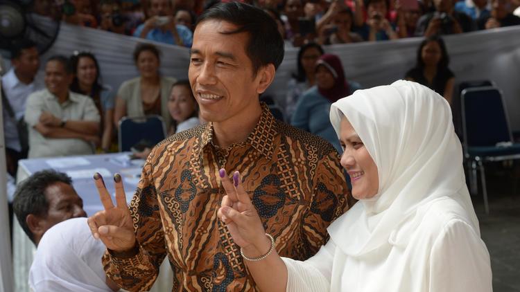 Joko Widodo (g), gouverneur de Jakarta et son épouse Iriana Widodo (d) votent dans la capitale indonésienne le 9 juillet 2014 [Adek Berry / AFP]