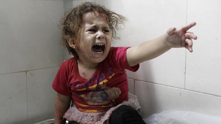 Une petite fille palestinienne hurle à l'hôpital al-Shifa après la destruction de la maison familiale de Gaza le 18 juillet 2014 [Mohamed Abed / AFP]