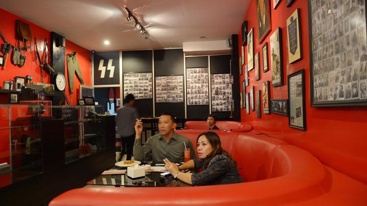 Des clients dînent à une table du "Soldaten Kaffee", un café d'inspiration nazie établi à Bandung en Indonésie [Adek Berry / AFP]