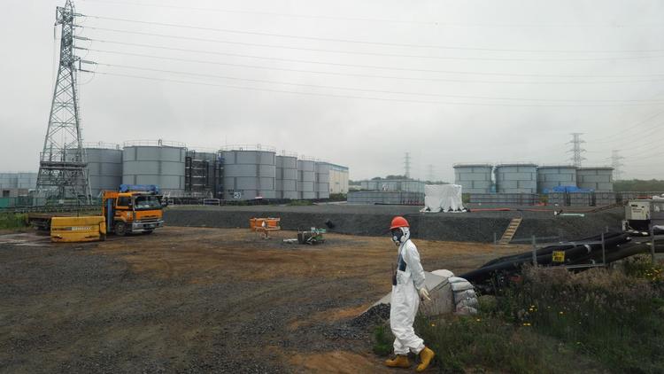 Un ouvrier marche à proximité des réservoirs d'eau de la centrale nucléaire de Fukushima, le 12 juin 2013   [Toshifumi Kitamura / Pool/AFP/Archives]