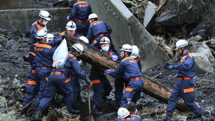 Des policiers dégagent des décombres à la recherche de victimes d'un glissement de terrain, le 21 octobre 2013 sur l'île d'Oshima, au Japon [JijiPress / JijiPress/AFP]