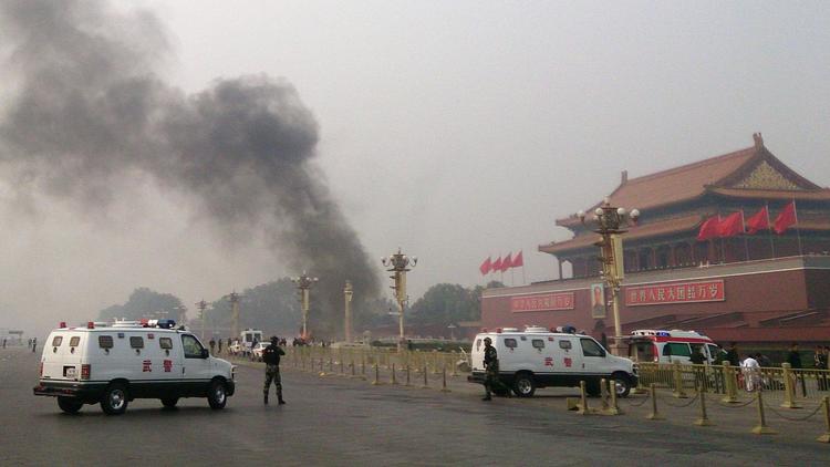 Des véhicules de police bloquent les accès à la place Tiananmen d'où s'élève une colonne de fumée, le 28 octobre 2013 à Pékin, suite à un attentat perpétré, selon la police, par trois extrémistes de l'ethnie ouïghoure de la région musulmane du Xinjiang [- / AFP/Archives]