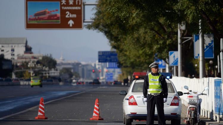 Un policier surveille l'avenue Chang'an aux abords de la place Tiananmen à Pékin, le 29 octobre 2013 [Ed Jones / AFP]