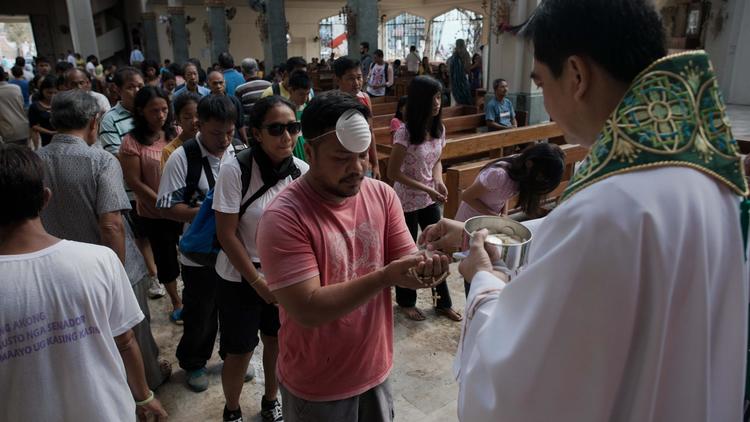 Des fidèles communient dans l'église dévastée de Santo Nino le 17 novembre 2013 à Tacloban [Nicolas Asfouri / AFP]