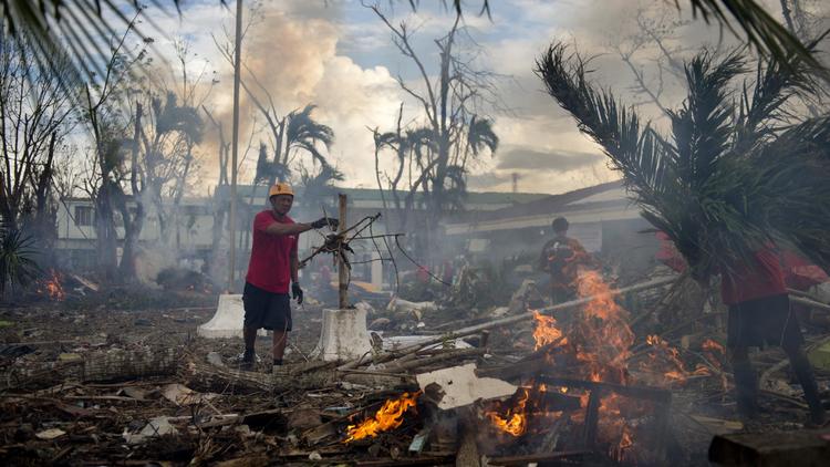 Des bénévoles de la Croix Rouge brûlent des débris après le passage du typhon Haiyan à Tacloban le 20 novembre 2013 [Odd Andersen / AFP]