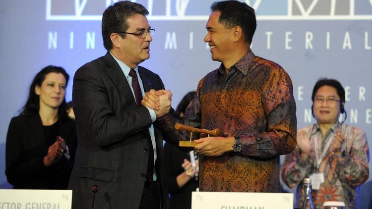 Le directeur général de l'OMC Roberto Azevedo (g) serre la main du ministre indonésien du Commerce Gita Wirjawan après un accord final, le 7 décembre 2013 à Nusa Dua, sur l'île indonésienne de Bali [Sonny Tumbelaka / AFP]