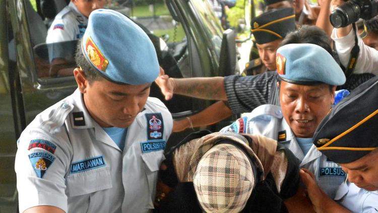 L'Australienne Schapelle Corby (c)escortée par des policiers après l'annonce de sa libération sous conditions, le 10 février 2014 à Bali [Bay Ismoyo / AFP]