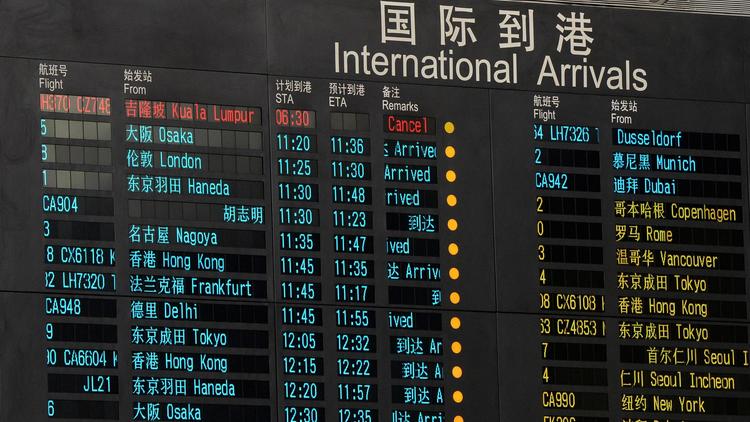 A l'aéroport de Pekin, le tableau des arrivées, montrant le vol annulé de Malaysia Airlines (en rouge en haut) suite à la disparition de l'avion des écrans radars entre le Vietnam et la Chine le 8 mars 2014 [Mark Ralston / AFP]