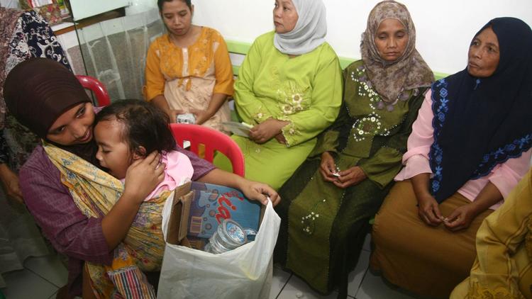 Une jeune maman apporte un sac de déchets à la clinique Bumi Ayu dans l'île de Java en échange de soins pour son enfant, le 26 avril 2014 [Aman Rochman / AFP/Archives]