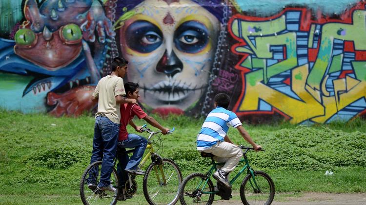 Des enfants font du vélo à Valle del Sol, un quartier près de la capitale du Guatemala, le 23 juin 2013 [Johan Ordonez / AFP]