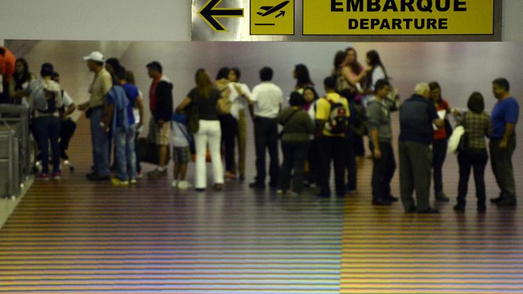Des voyageurs font la queue avec leurs bagages dans la zone de départ de l'aéroport de Caracas, le 3 juillet 2014 [Leo Ramirez / AFP]