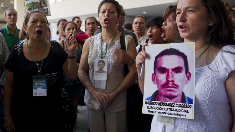 Un groupe de personnes demande que justice soit rendue pour les victimes de crimes commis par des groupes armés lors du Forum national dédié aux victimes, à Cali (Colombie) le 5 août 2014 [Luis Robayo / AFP]