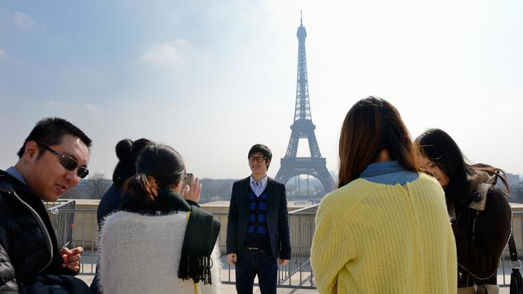 Des touristes chinois se prennent en photo devant la Tour Eiffel à Paris le 27 mars 2013 [Eric Feferberg / AFP/Archives]