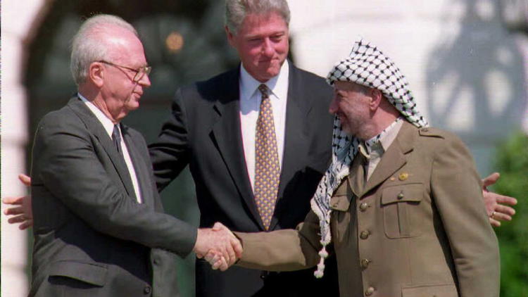 Le président américain Bill Clinton (c) assiste à la poignée de mains historique entre Yasser Arafat (d) et Yitzahk Rabin, le 13 septembre 1993 à la Maison Blanche [J. David Ake / AFP/Archives]