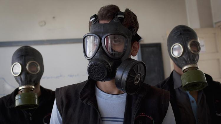 Des bénévoles portant des masques à gaz apprennent comment réagir face à une attaque chimique, le 15 septembre 2013 à Alep  [Jm Lopez / /AFP]