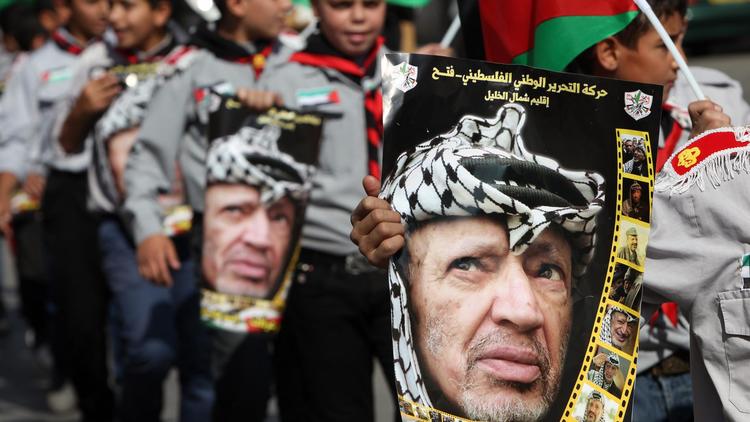 De jeunes Palestiniens portent des portraits de Yasser Arafat, lors d'un défilé à Hébron, en Cisjordanie, le 11 novembre 2013 [Hazem Bader / AFP]