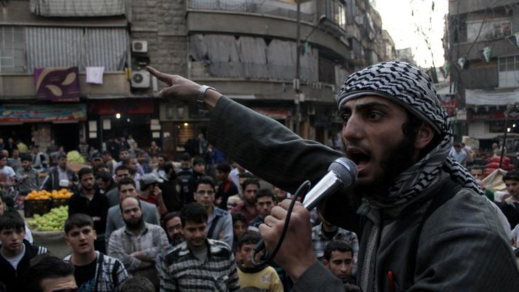 Un membre de l'EEIL (Etat Islamique en Irak et au Levant) en train de haranguer la foule pour chercher des volontaires désireux de se battre contre le régime syrien, à Alep, le 13 novembre 2013 [Karam al-Masri / AFP/Archives]
