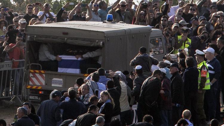 Des Israéliens prennent des photos du convoi transportant la dépouille d'Ariel Sharon à son arrivée au lieu de sa sépulture près de la ville de Sderot, le 13 janvier 2014 [Jack Guez / AFP]