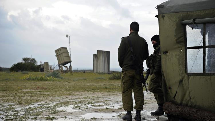 Deux soldats israéliens près d'un Dôme de fer, système de défense aérienne mobile, conçu pour intercepter et détruire les roquettes et les mortiers, près de Ashkelon, au sud d'Israël le 13 mars 2014 [David Buimovitch / AFP]