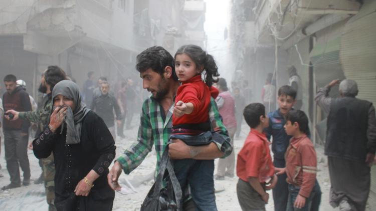 Des Syriens dans la ville d'Alep en Syrie, juste après des raids aériens, le 15 avril 2014 [Baraa Al-Halabi / AFP]