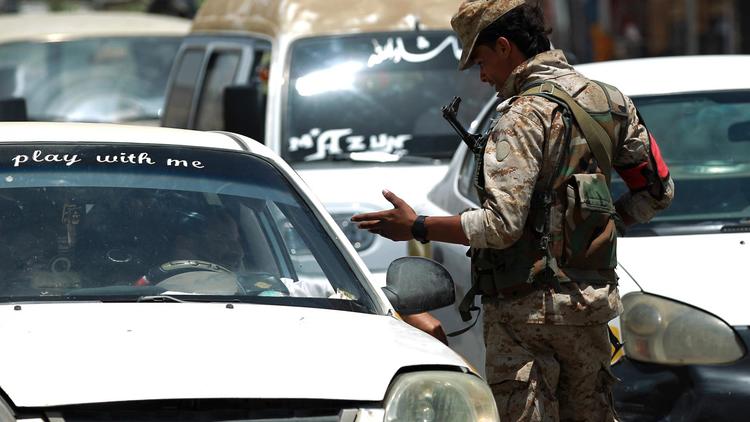 Un soldat yéménite discute avec un automobiliste à Sanaa le 20 avril 2014 alors que les mesures de sécurité sont renforcées suite à des attaques de drones [Mohammed Huwais / AFP]