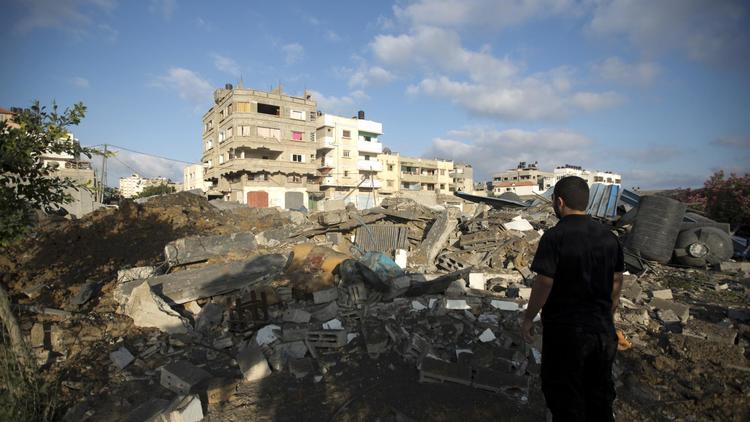 Un Palestinien regarde les dégâts provoqués par une frappe de l'aviation israélienne à Gaza, le 3 juillet 2014 [Mohammed Abed / AFP]