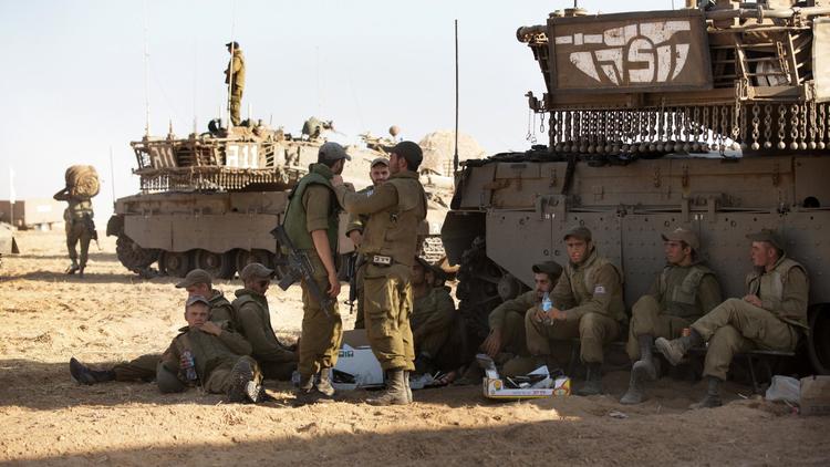 Des soldats israéliens stationnent près d'un véhicule blindé, à proximité de la frontière avec la bande de Gaza, le 10 juillet 2014 [Menahem Kahana / AFP]