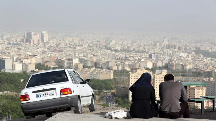 Un couple assis dans un quartier périphérique de Téhéran, le 7 juin 2014  [Atta Kenare / AFP]