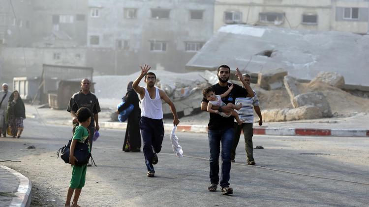Des Palestiniens fuient leur maison dans le quartier de Chajaya, à l'est de Gaza, le 20 juillet 2014 [Mohammed Abed / AFP]