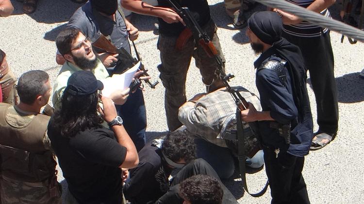 Des combattants jihadistes s'apprêtent à exécuter le 25 juillet 2014 deux hommes, inculpés par un tribunal islamique pour avoir commis plusieurs attentats à la voiture piégée dans la province Idlib  [Amr Radwan Al-Homsi / AFP]