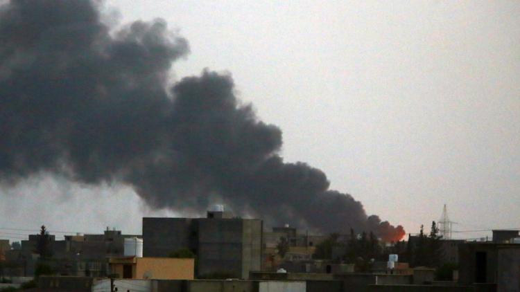 Des colonnes de fumée s'échappent d'un entrepôt de carburant incendié, lors de combats pour la prise de l'aéroport, le 30 juillet 2014 [Mahmud Turkia / AFP]