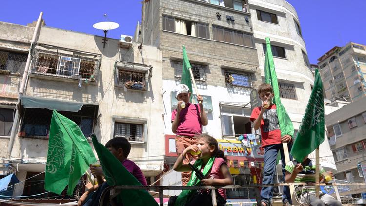 Les drapeaux verts du mouvement islamite Hamas portés par des enfants à Gaza le 7 aout 2014, au troisième jour de la trève avec Israel, que le mouvement islamiste a décidé de ne pas poursuivre [Roberto Schmidt / AFP]
