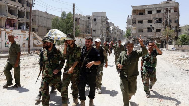Les forces gouvernementales syriennes font le signe de la victoire à Mleiha dans la banlieue de Damas le 15 août 2014 [Louai Beshara / AFP]